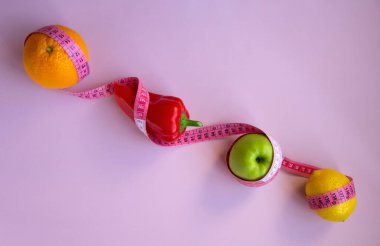 Elma, biber, limon, turuncu ve pembe arka planda şeritli yaratıcı düz kompozisyon. Aralıklı, keto, detoks ve ince diyetler. Sağlıklı beslenme konsepti. Boşluğu kopyala.