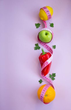 Pembe arka planda mezuralı taze meyve ve sebzelerle moda. Aralıklı, keto, detoks ve ince diyetler. Sağlıklı beslenme konsepti. Düz yat, boşluğu kopyala.