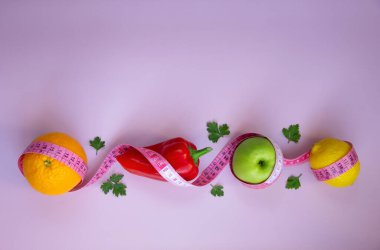 Elma, biber, limon, turuncu ve pembe arka planda şeritli yaratıcı düz kompozisyon. Aralıklı, keto, detoks ve ince diyetler. Sağlıklı beslenme konsepti. Boşluğu kopyala.