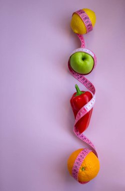 Pembe arka planda mezuralı taze meyve ve sebzelerle moda. Aralıklı, keto, detoks ve ince diyetler. Sağlıklı beslenme konsepti. Düz yat, boşluğu kopyala.
