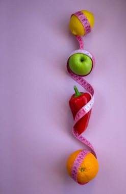 Elma, biber, limon, turuncu ve pembe arka planda şeritli yaratıcı düz kompozisyon. Aralıklı, keto, detoks ve ince diyetler. Sağlıklı beslenme konsepti. Boşluğu kopyala.