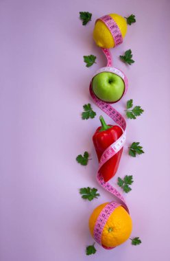 Elma, biber, limon, turuncu ve pembe arka planda şeritli yaratıcı düz kompozisyon. Aralıklı, keto, detoks ve ince diyetler. Sağlıklı beslenme konsepti. Boşluğu kopyala.