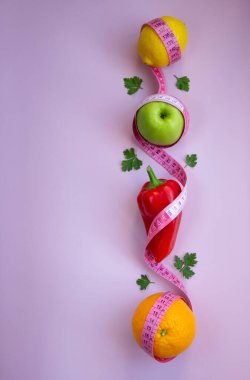 Elma, biber, limon, turuncu ve pembe arka planda şeritli yaratıcı düz kompozisyon. Aralıklı, keto, detoks ve ince diyetler. Sağlıklı beslenme konsepti. Boşluğu kopyala.