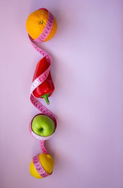 Elma, biber, limon, turuncu ve pembe arka planda şeritli yaratıcı düz kompozisyon. Aralıklı, keto, detoks ve ince diyetler. Sağlıklı beslenme konsepti. Boşluğu kopyala.