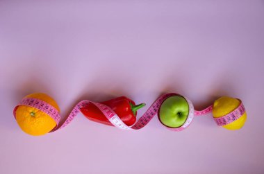 Elma, biber, limon, turuncu ve pembe arka planda şeritli yaratıcı düz kompozisyon. Aralıklı, keto, detoks ve ince diyetler. Sağlıklı beslenme konsepti. Boşluğu kopyala.