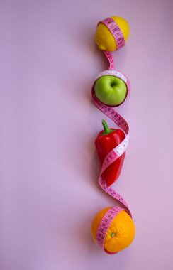 Pembe arka planda mezuralı taze meyve ve sebzelerle moda. Aralıklı, keto, detoks ve ince diyetler. Sağlıklı beslenme konsepti. Düz yat, boşluğu kopyala.