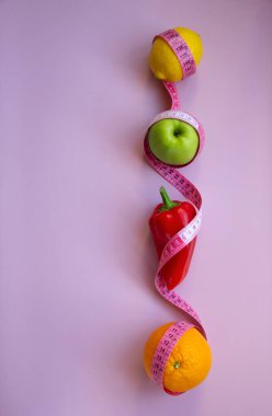 Elma, biber, limon, turuncu ve pembe arka planda şeritli yaratıcı düz kompozisyon. Aralıklı, keto, detoks ve ince diyetler. Sağlıklı beslenme konsepti. Boşluğu kopyala.