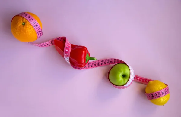 Tvůrčí Plochá Kompozice Jablkem Pepřem Citrónem Pomerančem Měřicí Páskou Růžovém — Stock fotografie