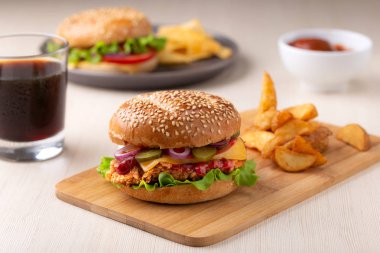Burger dilimlenmiş turşu, soğan ve patates kızartması ile