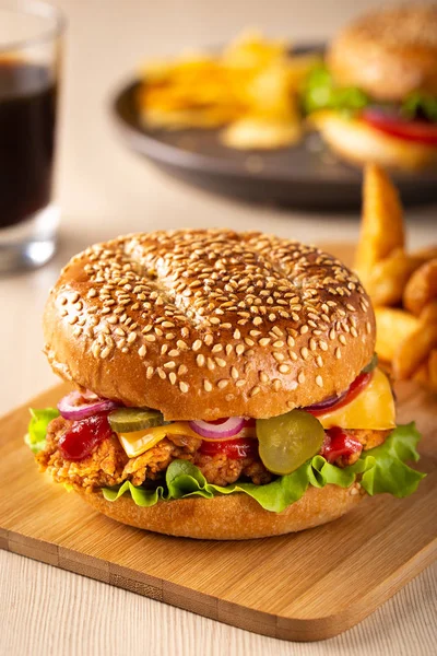 Burger with sliced pickle, onion and fried potatoes