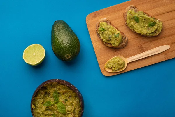 Guacamole tál összetevőket a kék háttér. Felülnézet — Stock Fotó