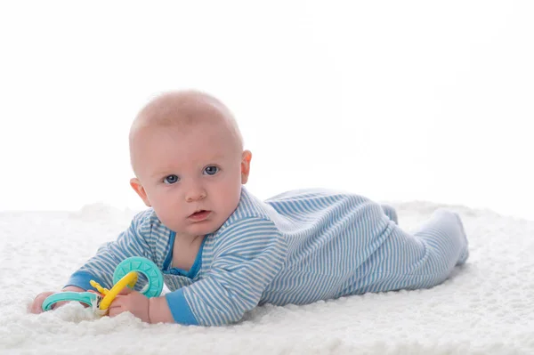 Menino Meses Deitado Barriga Cobertor Branco Ele Está Segurando Anéis — Fotografia de Stock