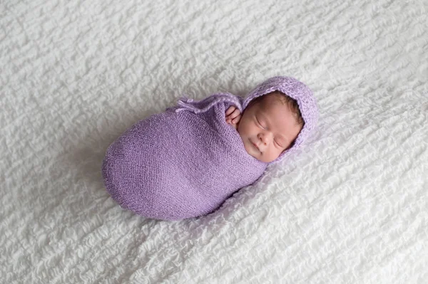 一个微笑 两个星期的新生女婴襁褓在薰衣草包装和穿着钩编帽子 在演播室拍摄的白色毯子 — 图库照片