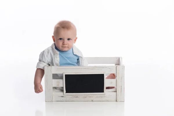 一个七月大的小男孩坐在白色的黑板板条箱里 拍摄在演播室在白色 无缝的背景 — 图库照片