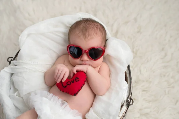 신생아 모양의 선글라스 그녀는 그것에 단어와 모양의 베개를 들고는 — 스톡 사진