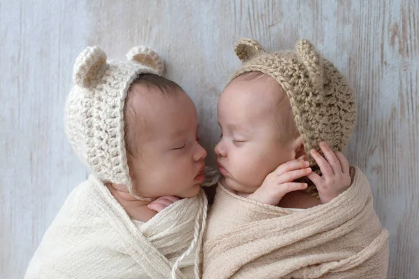Девочки-близнецы, несущие медвежьи капоты — стоковое фото