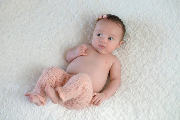 Baby flicka klädd i rosa stickade byxor — Stockfoto