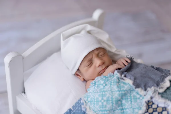 Menino recém-nascido dormindo em uma pequena cama — Fotografia de Stock