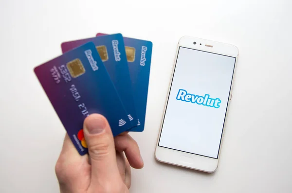 휴대 전화에 응용 프로그램을 켜고 Revolut 모바일 은행 카드를 들고 — 스톡 사진