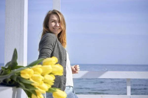 Una chica se levanta en el fondo del paseo marítimo —  Fotos de Stock