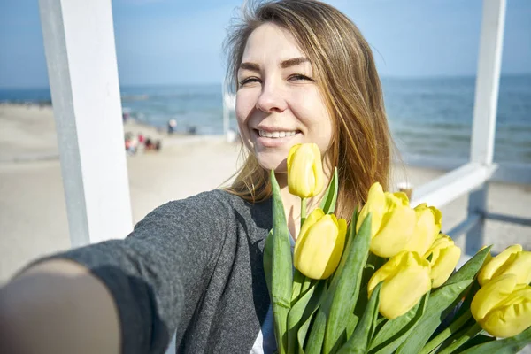 Frau mit Blumen (gelbe Tulpen). Selfie machen — Stockfoto