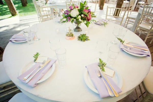 Сервировка стола и цветочные композиции — стоковое фото