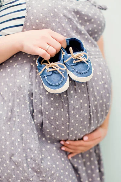 Pregnant woman with small baby shoes — Stock Photo, Image