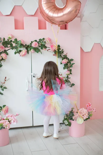 Mała dziewczynka w pobliżu białych drzwi z różowymi róż — Zdjęcie stockowe