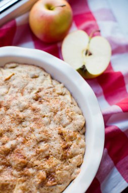Pişirme formunda taze elmalı turta. Elmalı turta ve kırmızı peçetede taze elmalar.