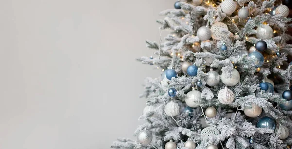 Gümüş, mavi süslemeleri ve ışıkları olan Noel ağacıyla Noel afişi. Kopya alanı olan beyaz bir arkaplanda Noel ağacı, metin için yer