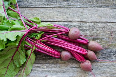 Kırsal ahşap arka planda yaprakları olan taze organik pancar. Üst görünüm, alanı kopyala.