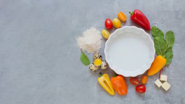 Renkli domatesli turta ve gri arka planda biber pişirmek için malzemeli fırın yemeği.