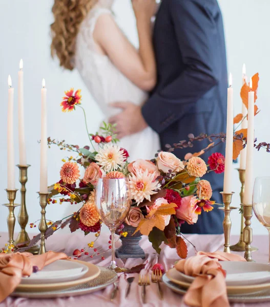 秋の結婚式のコンセプト 秋の花 ろうそく テーブルセッティングで飾られたテーブルの近くの新郎新婦 — ストック写真