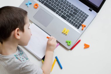 Distance online education concept. Little caucasian boy have video call studies online on laptop, homeschooling concept. Kindergarten online study clipart