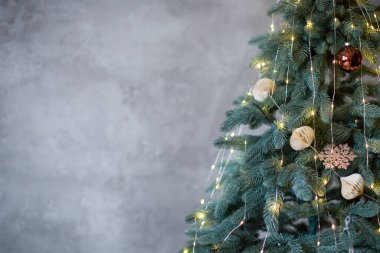 Kırsal bir Noel ağacı olan pankart. Işıklar ve gri beton arka planda el yapımı süslemeler.