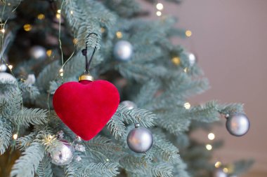 Kırmızı kalpli Noel ağacı ve beyaz duvarlı ışıklar.