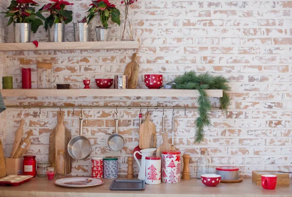 Light kitchen with brick walls and red Christmas decorations and lights