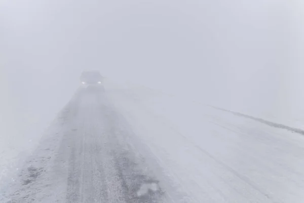 Strada e una macchina nella nebbia — Foto Stock