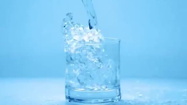 Наливание стакана воды в замедленной съемке — стоковое видео