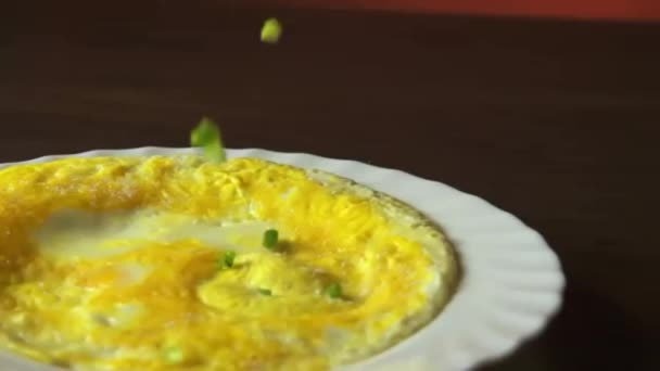 W plasterek zielona cebula spadnie na omlet — Wideo stockowe