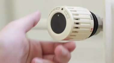 Radiator thermostat, selective focus, white background, turned down from level 4 to level 11