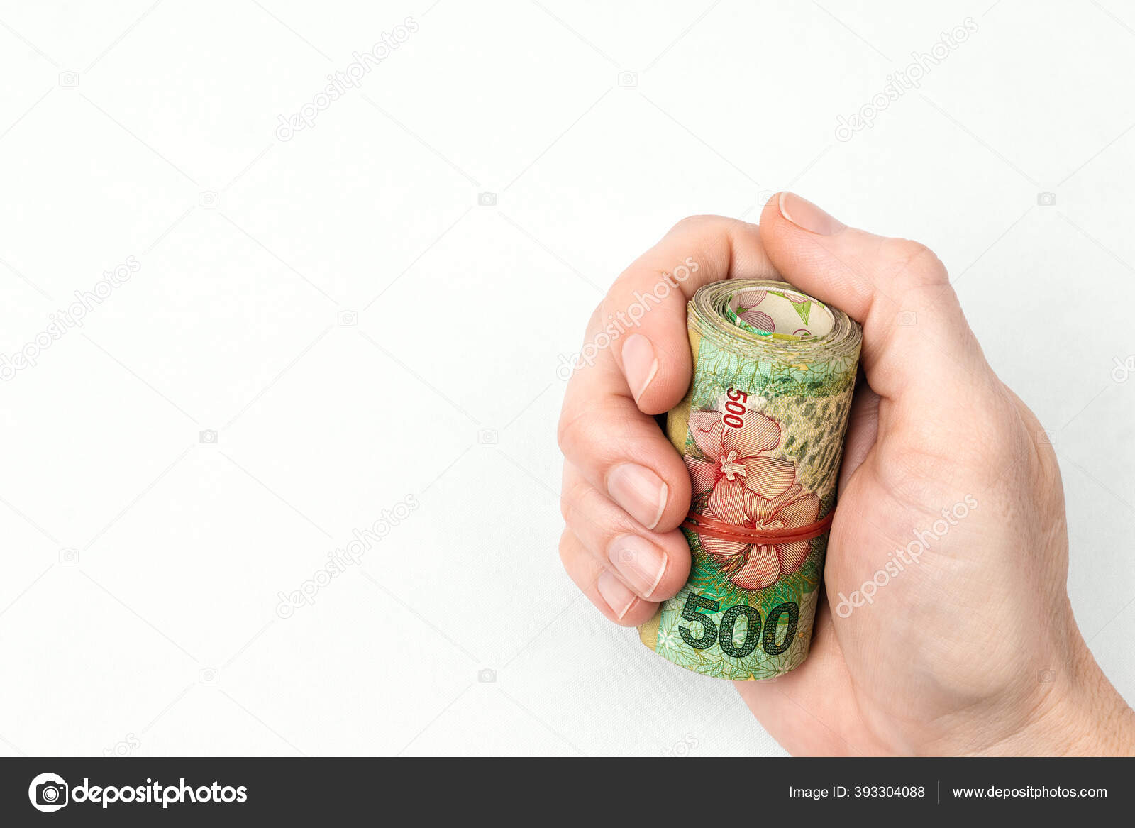 白种人白皙的白皙手和没有釉质的短指甲紧握着她紧握着的拳头手里拿着一束500阿根廷比索的钞票