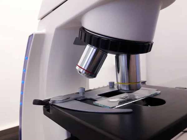 Laboratuvarda metal mercekle mikroskobun yakın çekim görüntüsü.