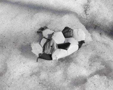 kar üzerinde yatan futbol oynamak için yırtık top