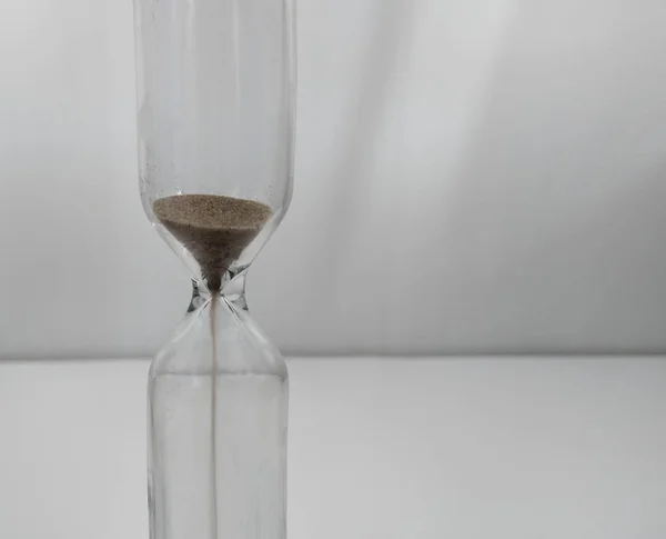 Sand running through the bulbs of an hourglass measuring the passing time in a countdown