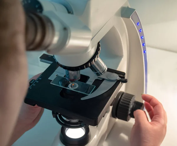 The girl in the lab works with a microscope — Stock Photo, Image