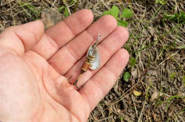 Fiske tillbehör. Grannlåt och beten liggande på en hand — Stockfoto