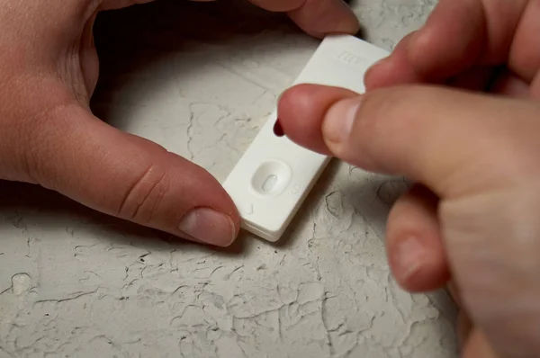 HIV self-test finger with a drop of blood. Hiv test express.