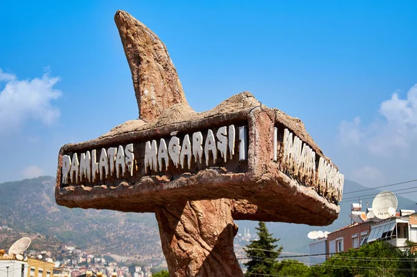 Mağara girişinin önünde duran 'Damlataş Mağaraları' tabelası. Alanya, Türkiye'de Gezi.