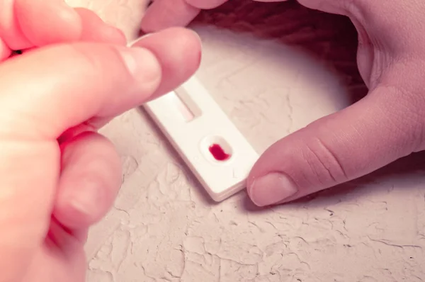 HIV self-test finger with a drop of blood. Hiv test express.